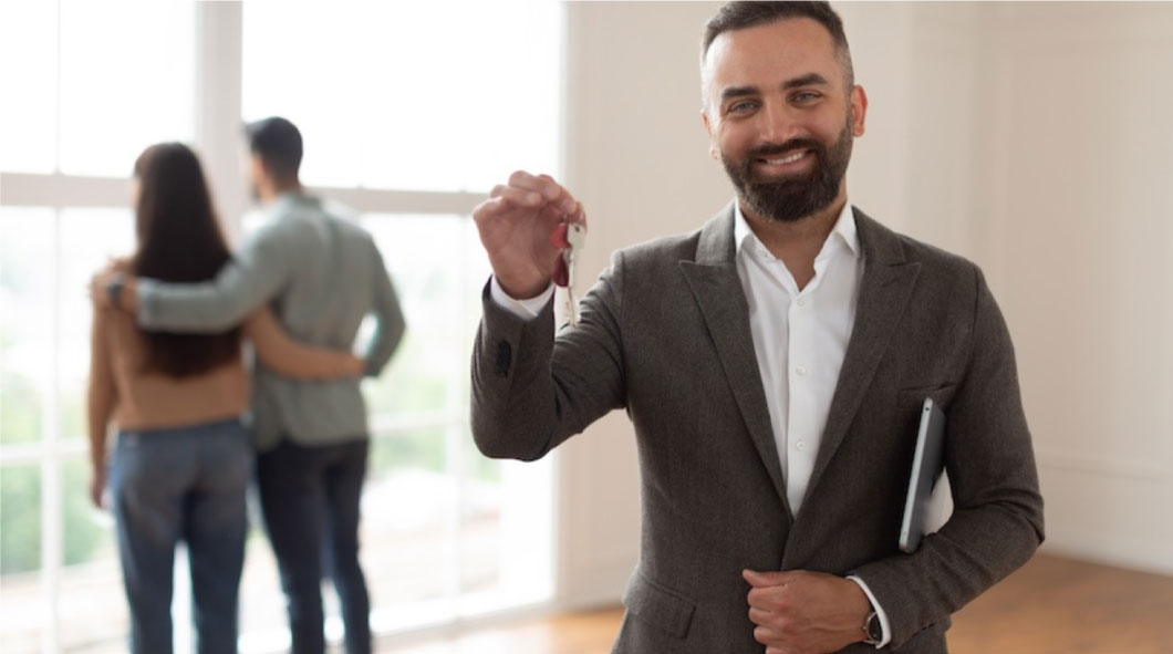 Estate agent smiling with couple standing in the backing